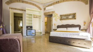 A spacious bedroom with a large bed, a walk-in closet, and a chandelier. - Trastevere Royal Suite (Rome)