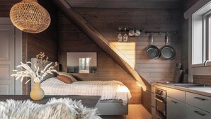 A cozy bedroom with a large window, a wooden ceiling, and a kitchen area with modern appliances. - Joe Getaway - Stugby Ullared (Ullared)