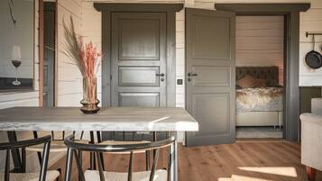 Ett kompakt bostadsutrymme med en matplats, en soffa och en säng.