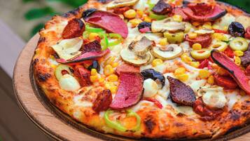 Una pizza con diferentes ingredientes sobre una tabla de madera.