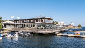 Un hotel con muelle, barcos y vistas despejadas al agua.