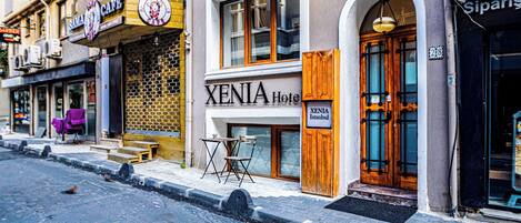 A hotel named XENIA with a wooden door and a sign indicating it is in Istanbul.
