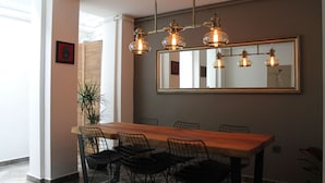 A dining area with a wooden table, black wire chairs, and a large mirror above the table. - Xenia Hotel (Istanbul)