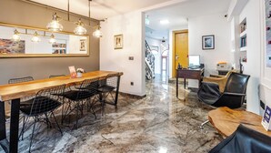 A modern hotel lobby with a marble floor, a wooden reception desk, black wireframe chairs, and a chandelier. - Xenia Hotel (Istanbul)