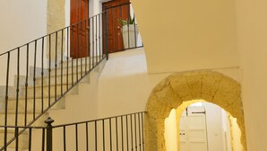 Un escalier surmonté d’une arche en pierre menant à une porte.