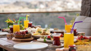 Una mesa de desayuno con diferentes platos, bebidas y acompañamientos.