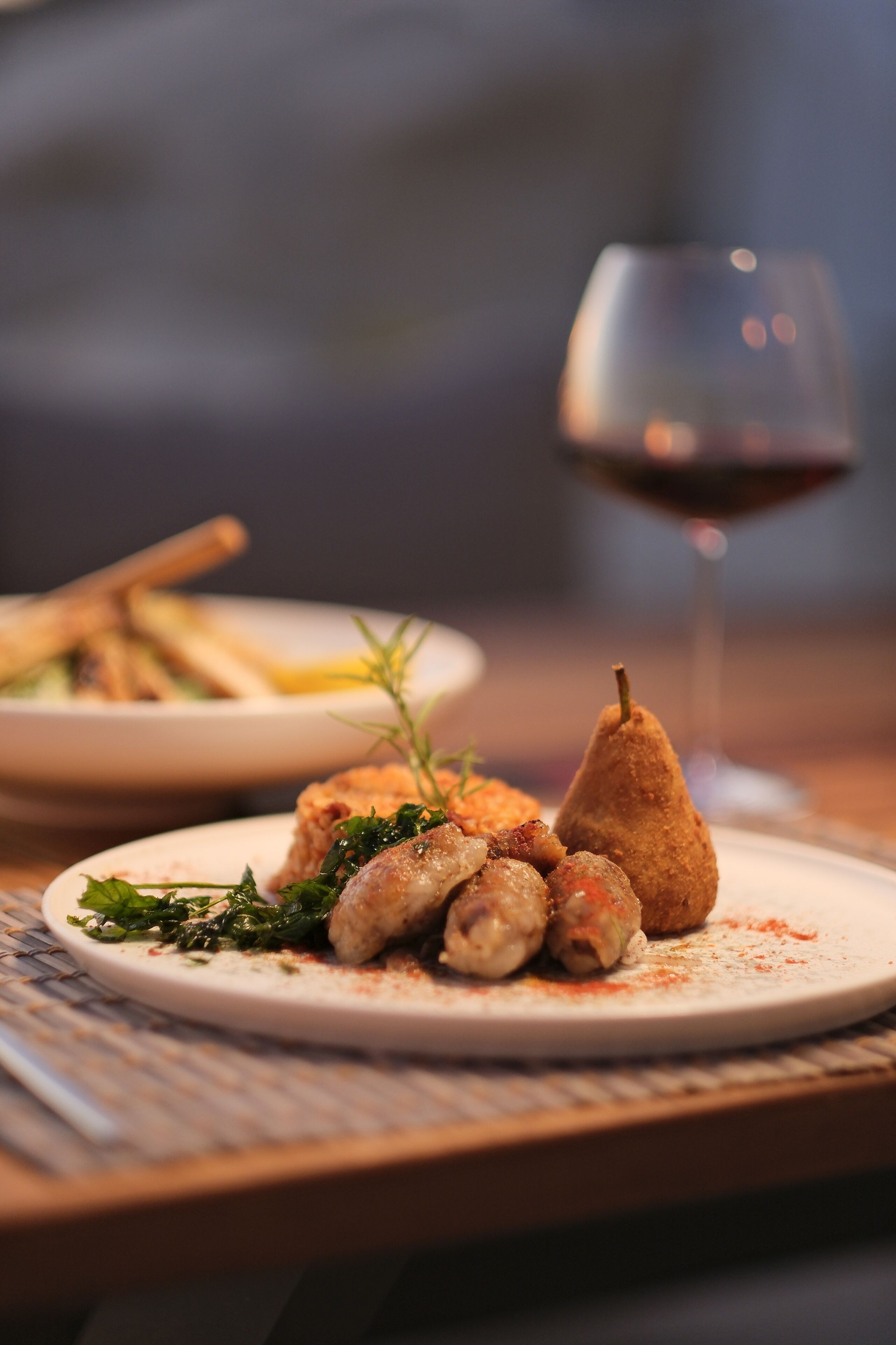 A plate of food with a glass of red wine.