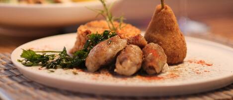 A plate of food with a glass of red wine.