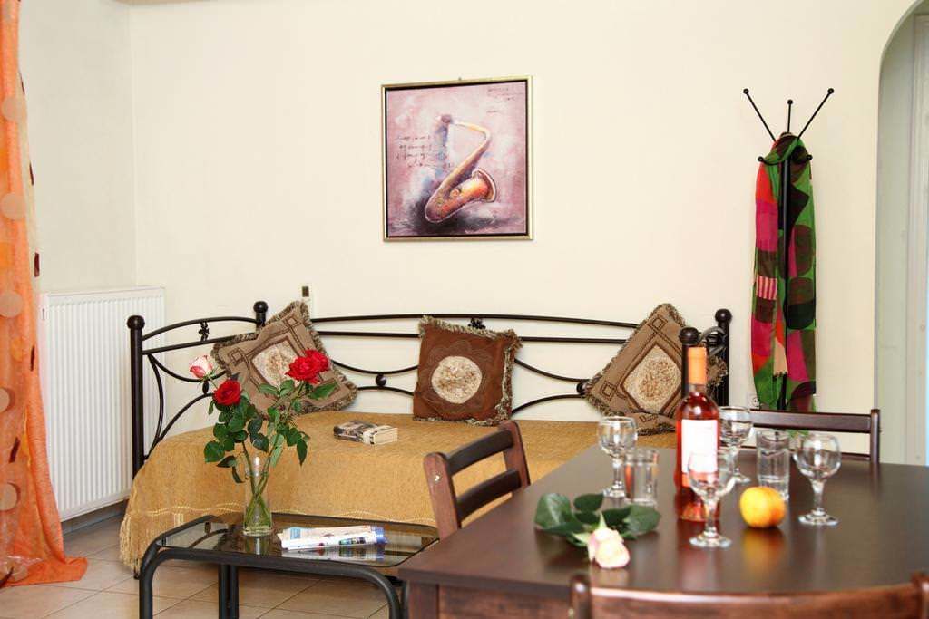 A cozy room with a bed, a dining table with wine glasses, and a painting on the wall.