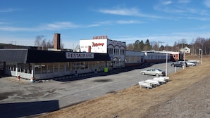 A building with a 'HOTEL' sign, a 'RESTAURANT' sign, and a 'JAGENS' sign. - Highway (Harnosand)