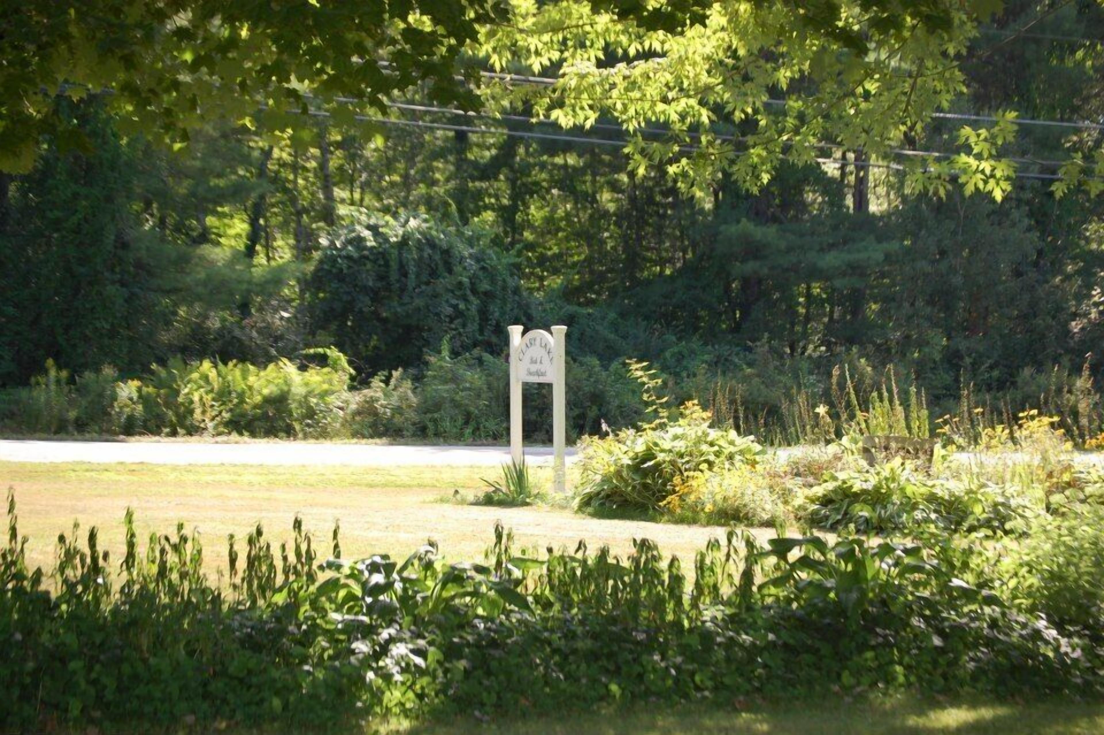 A signpost in a natural setting with dense foliage in the background.