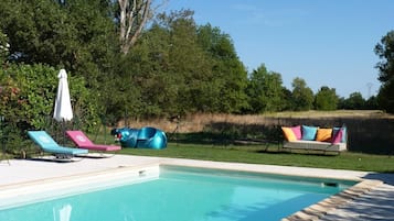 Alberca al aire libre y camastros
