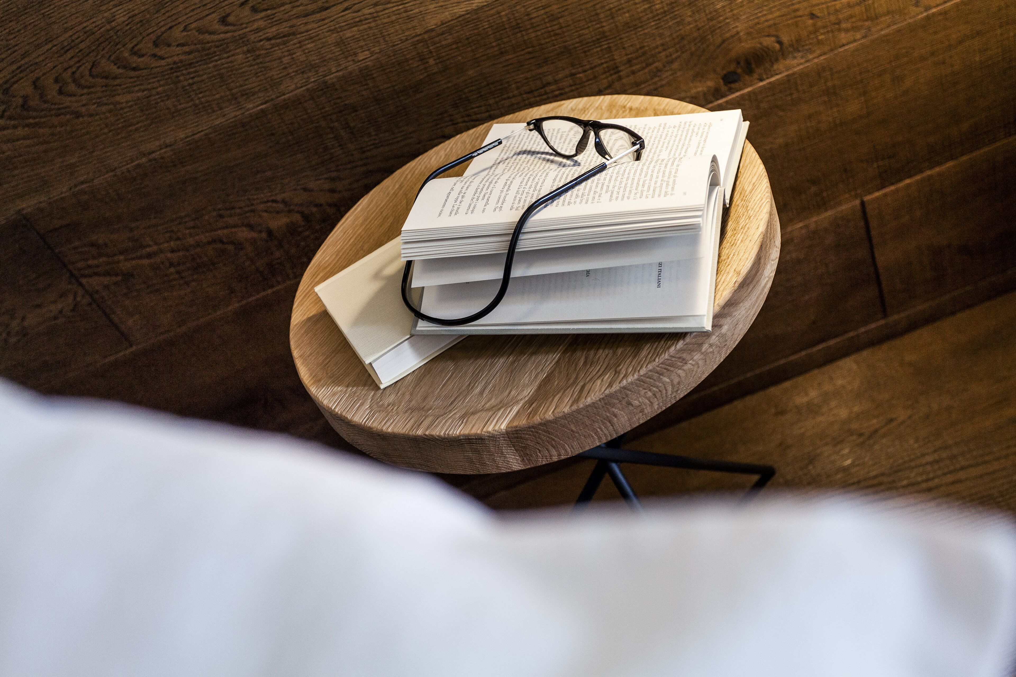 Une pile de livres et de lunettes sur une table en bois.
