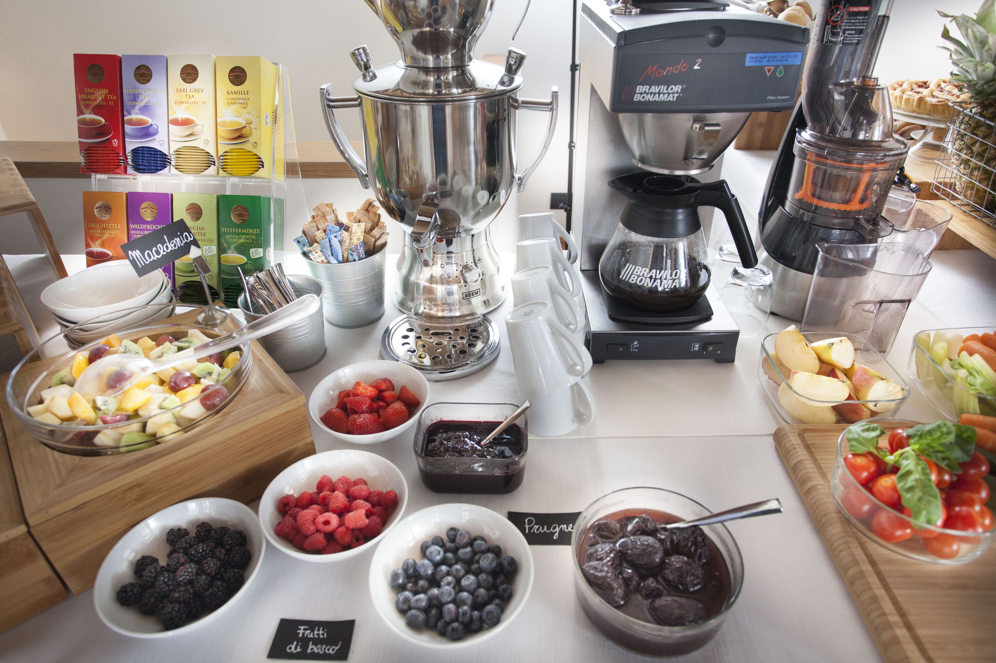 A buffet setup with various food items and a coffee machine.
