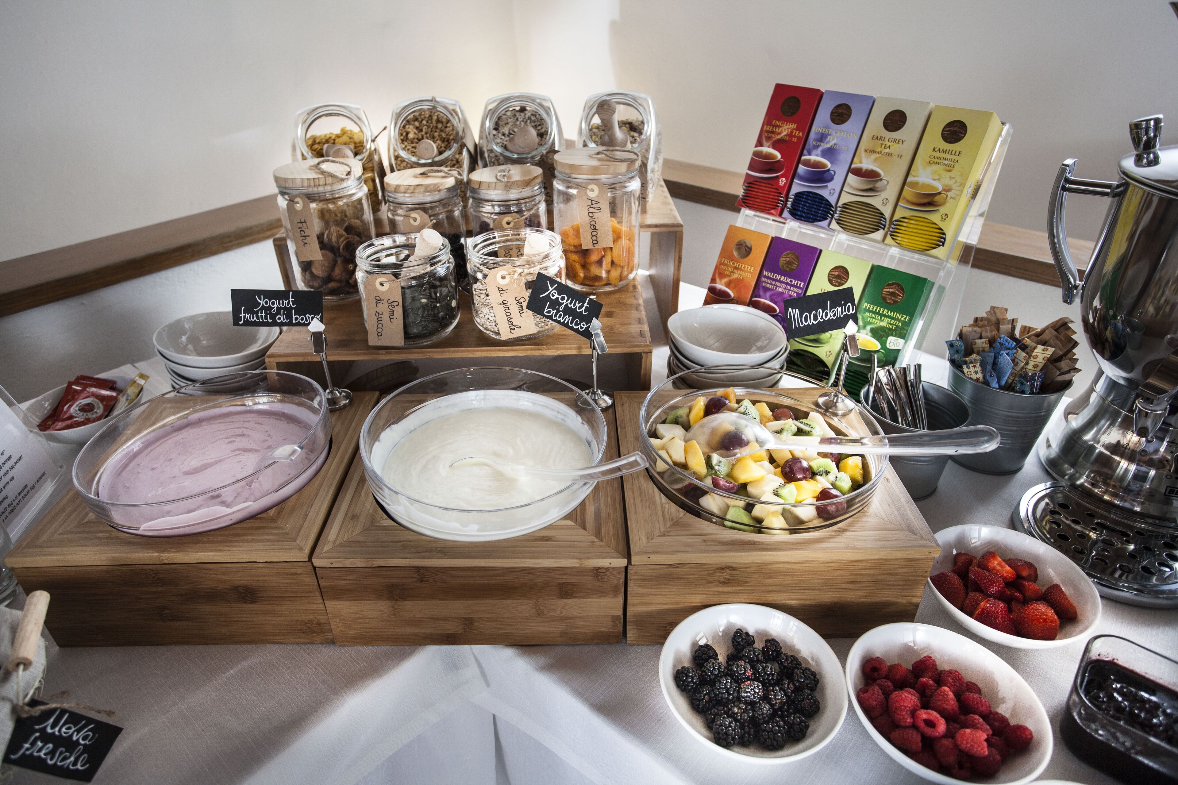 A buffet with various food items including yogurt, fruits, and snacks.