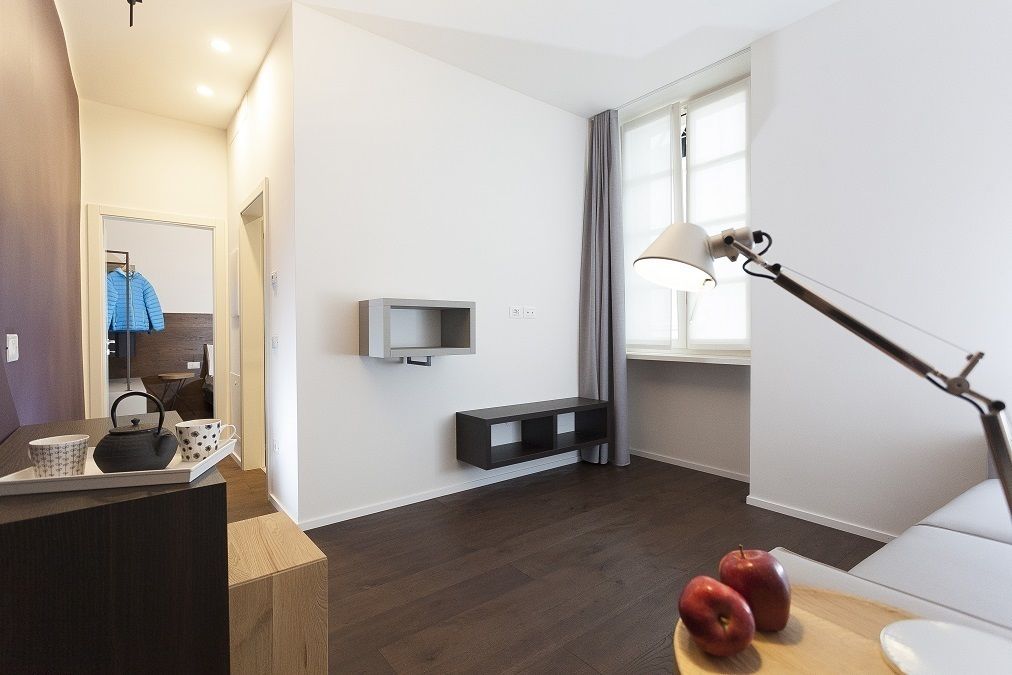 Un soggiorno moderno con una TV a schermo piatto, un tavolino con delle mele, una lampada e un mobile porta TV.