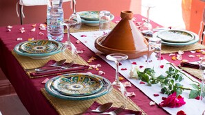 A table set with Moroccan-style plates, a tagine, and water bottles. - Riad El Gnaouia (Marrakech)
