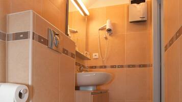 Un baño con inodoro, lavamanos y ducha.