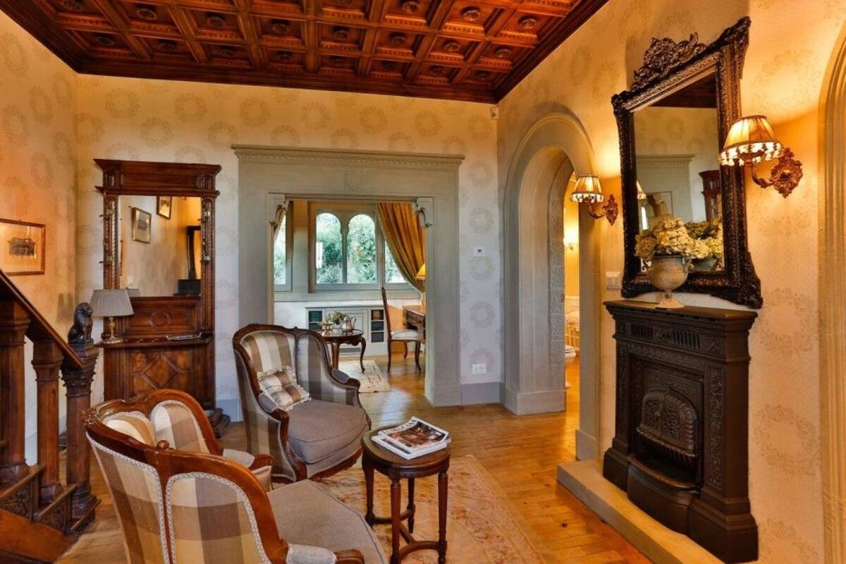 Una sala de estar tradicional con chimenea, muebles de madera y un espejo grande.