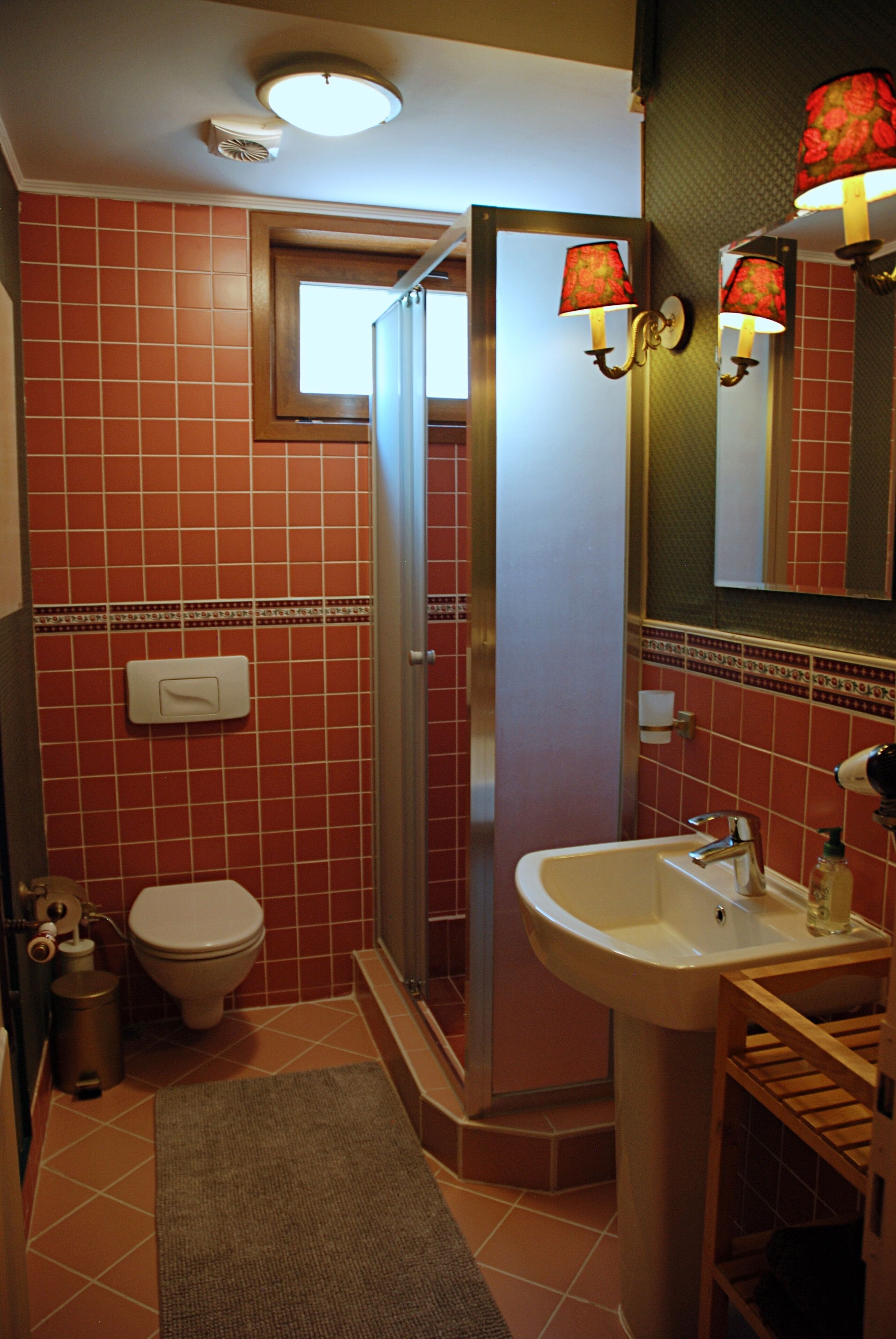 A bathroom with a toilet, sink, and shower.
