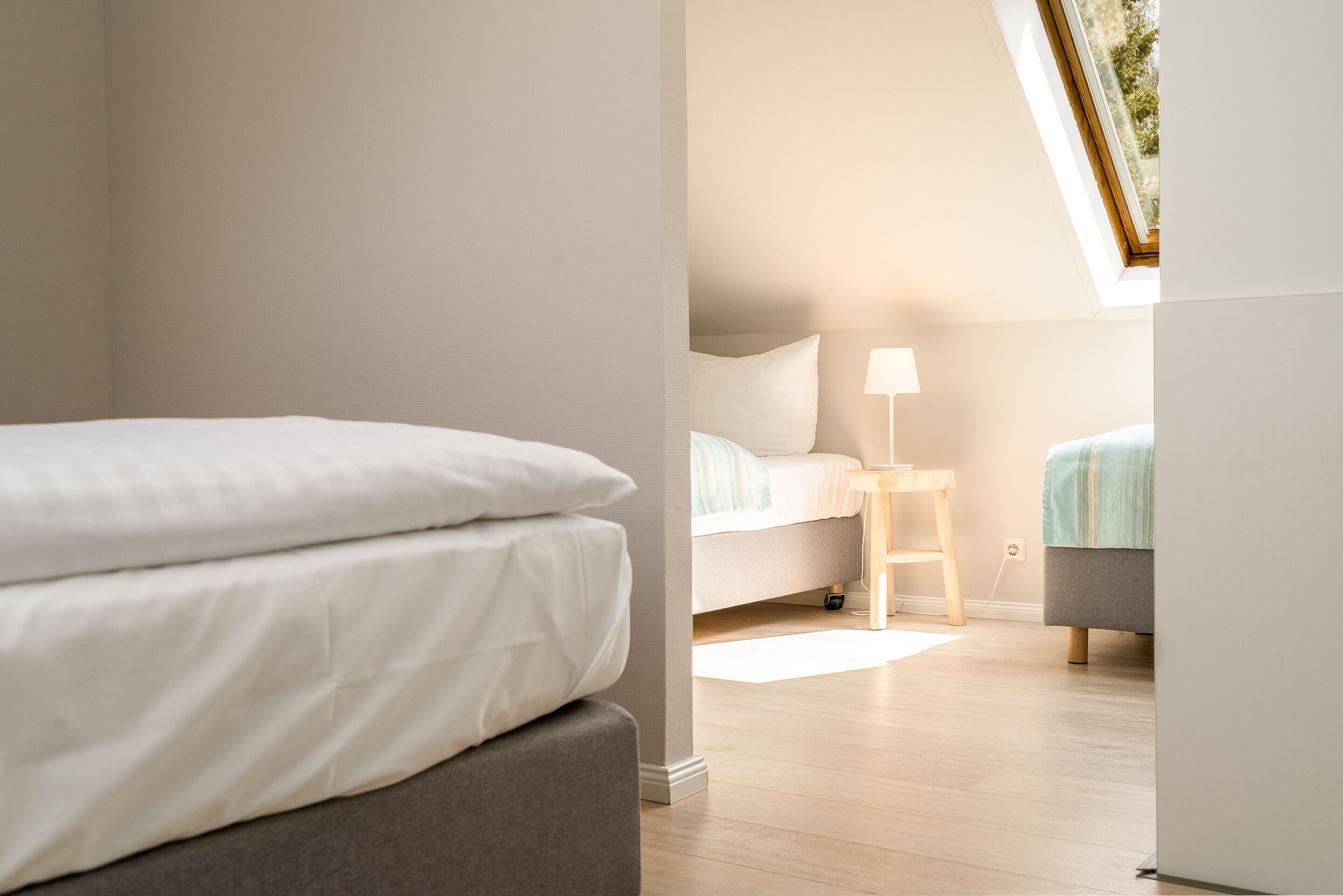 Un dormitorio con cama, mesita de noche y lámpara.
