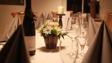 Una mesa de comedor con copas de vino, una botella de vino y un centro de mesa floral.