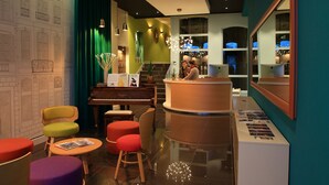 Eine Lobby mit Klavier, Sitzgelegenheiten und einer Rezeption.