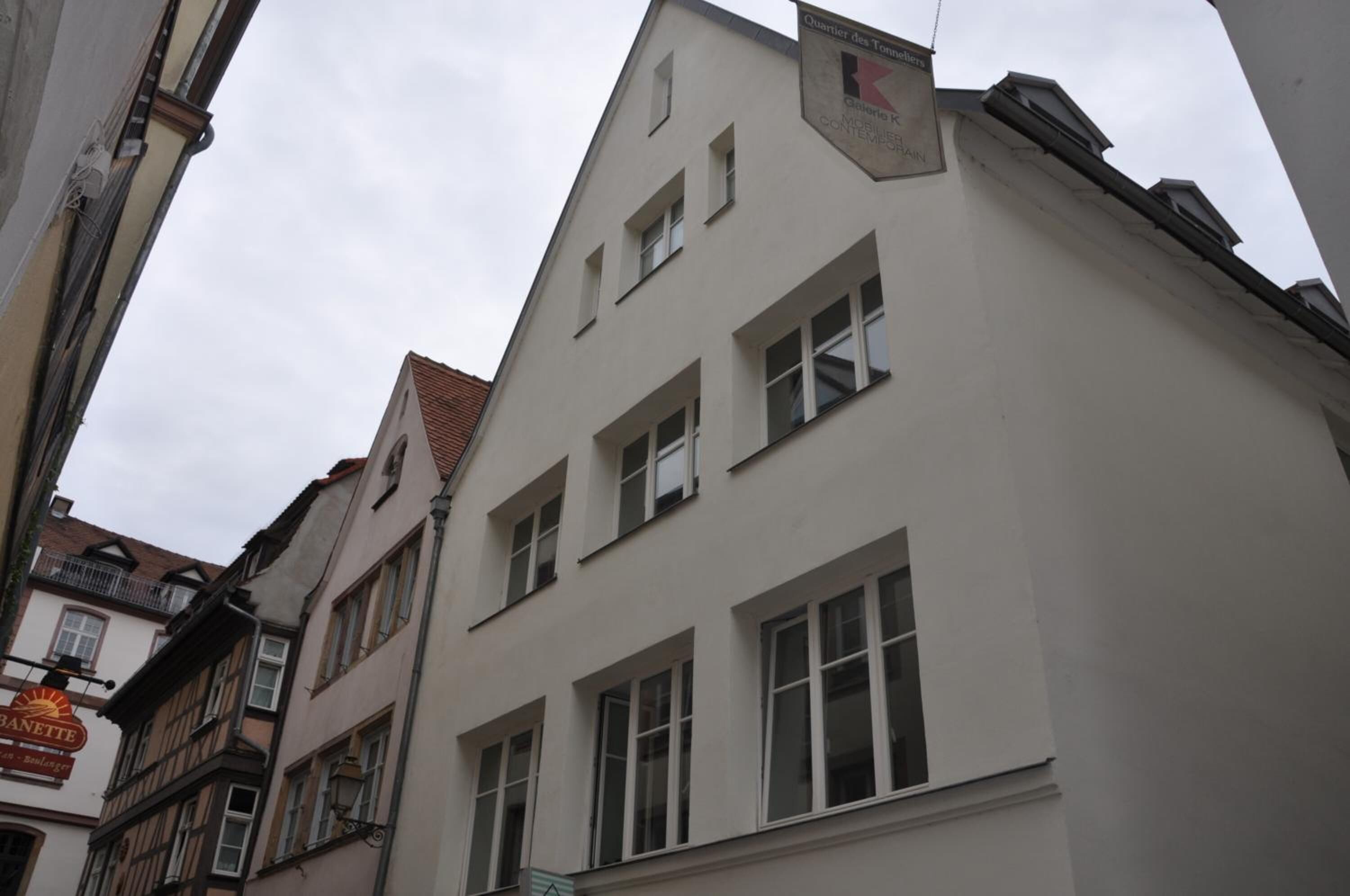 Un edificio de varios pisos con fachada blanca y numerosas ventanas.