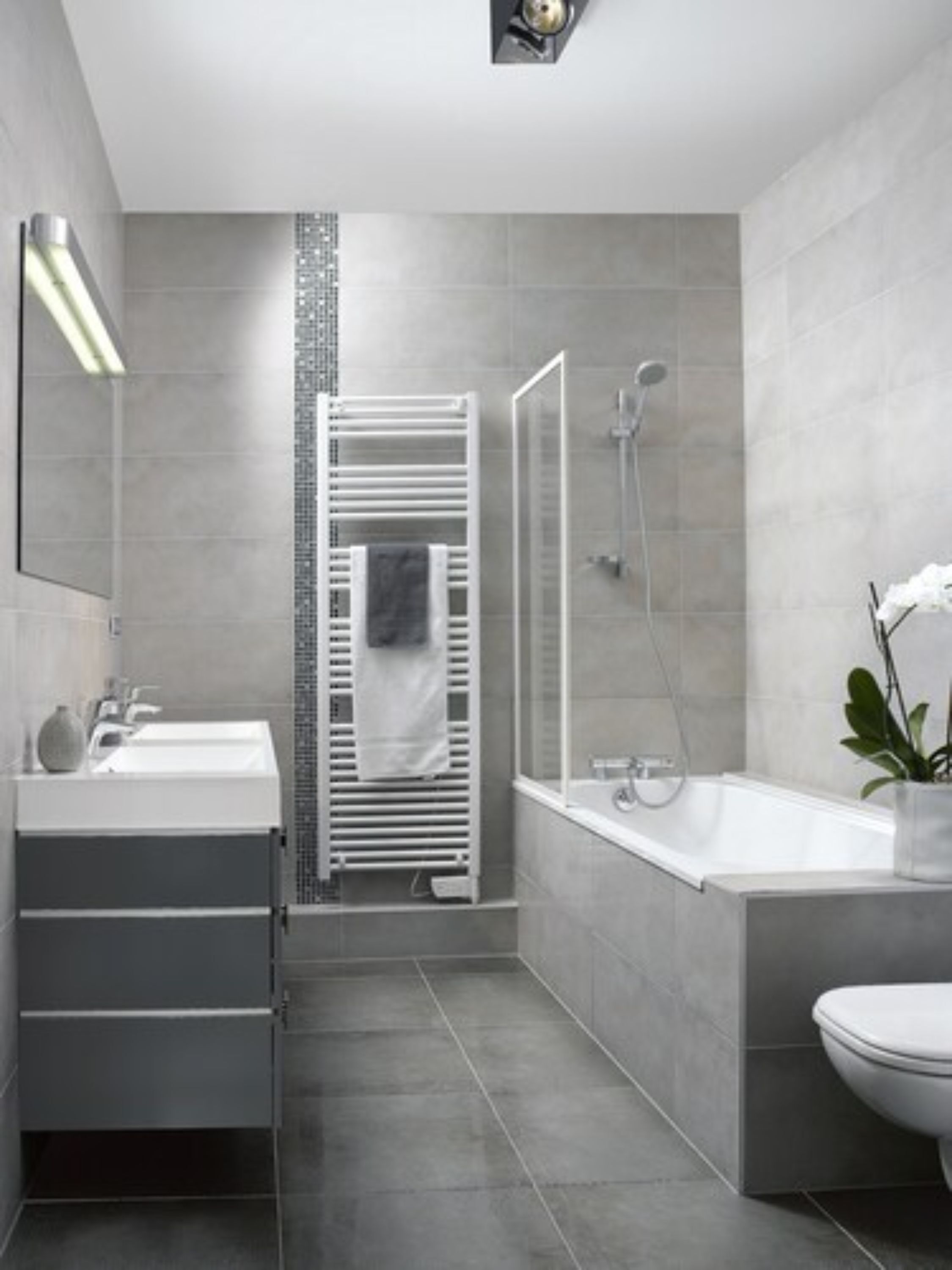 A modern bathroom with a shower, toilet, and sink.