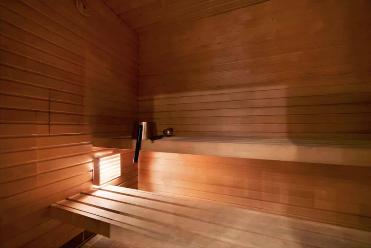 A sauna with wooden benches and a bench with a backrest.