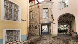 A narrow cobblestone street with buildings on either side, a metal gate, and a sign indicating a "Tooth Room." - Tallinn City Apartments Toompea Old Town (Tallinn)
