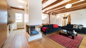 A modern living room with wooden beams, a fireplace, two sofas, and a coffee table. - Tallinn City Apartments Toompea Old Town (Tallinn)