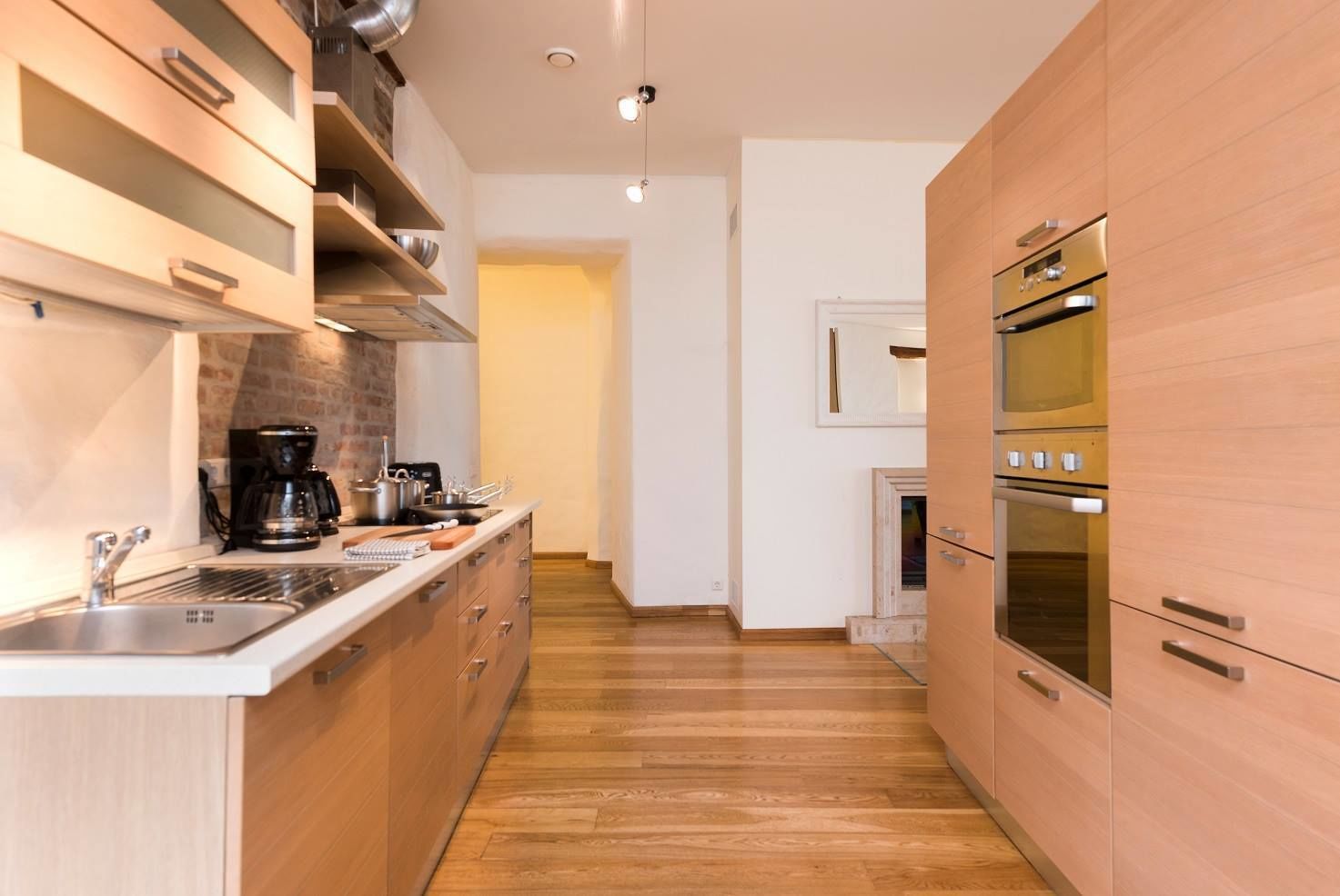 Una cocina moderna con armarios de madera, electrodomésticos de acero inoxidable y una isla central.