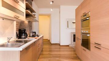 Una cocina moderna con armarios de madera, electrodomésticos de acero inoxidable y una isla central.