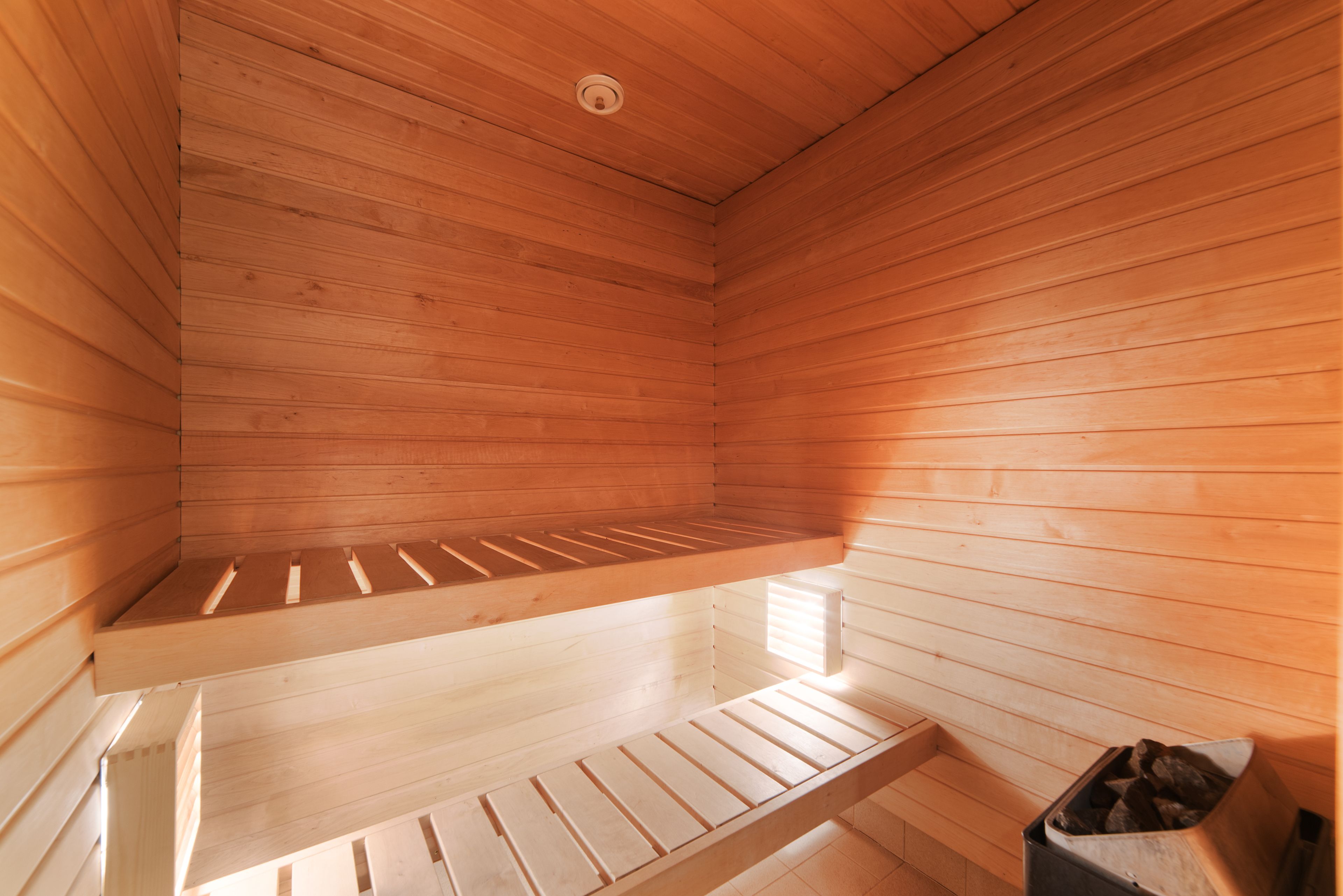 Una sala de sauna con paredes y bancos de madera.