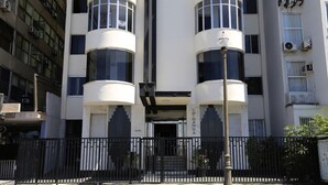 A modern building with a symmetrical facade, featuring cylindrical balconies and a central entrance. - MZ Apartments Atlantica posto 6 (Rio de Janeiro)