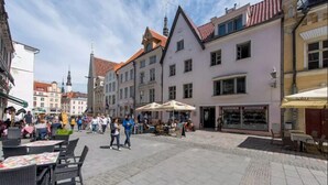 A bustling square with outdoor seating, historic buildings, and a shop selling souvenirs.