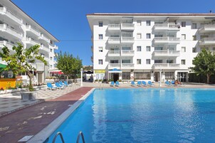 Una piscina al aire libre de temporada, sombrillas