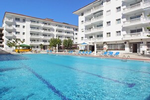 Una piscina al aire libre de temporada, sombrillas