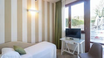 Ein Hotelzimmer mit Bett, Schreibtisch mit Fernseher und Stuhl.