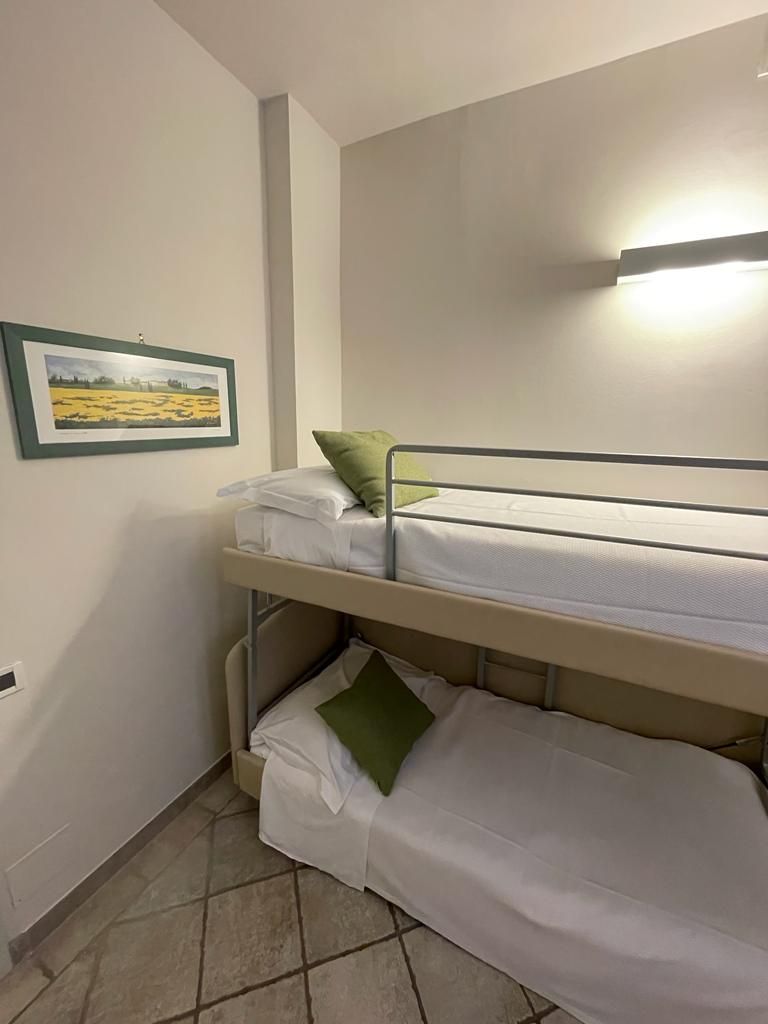 A bunk bed room with a framed landscape painting on the wall.