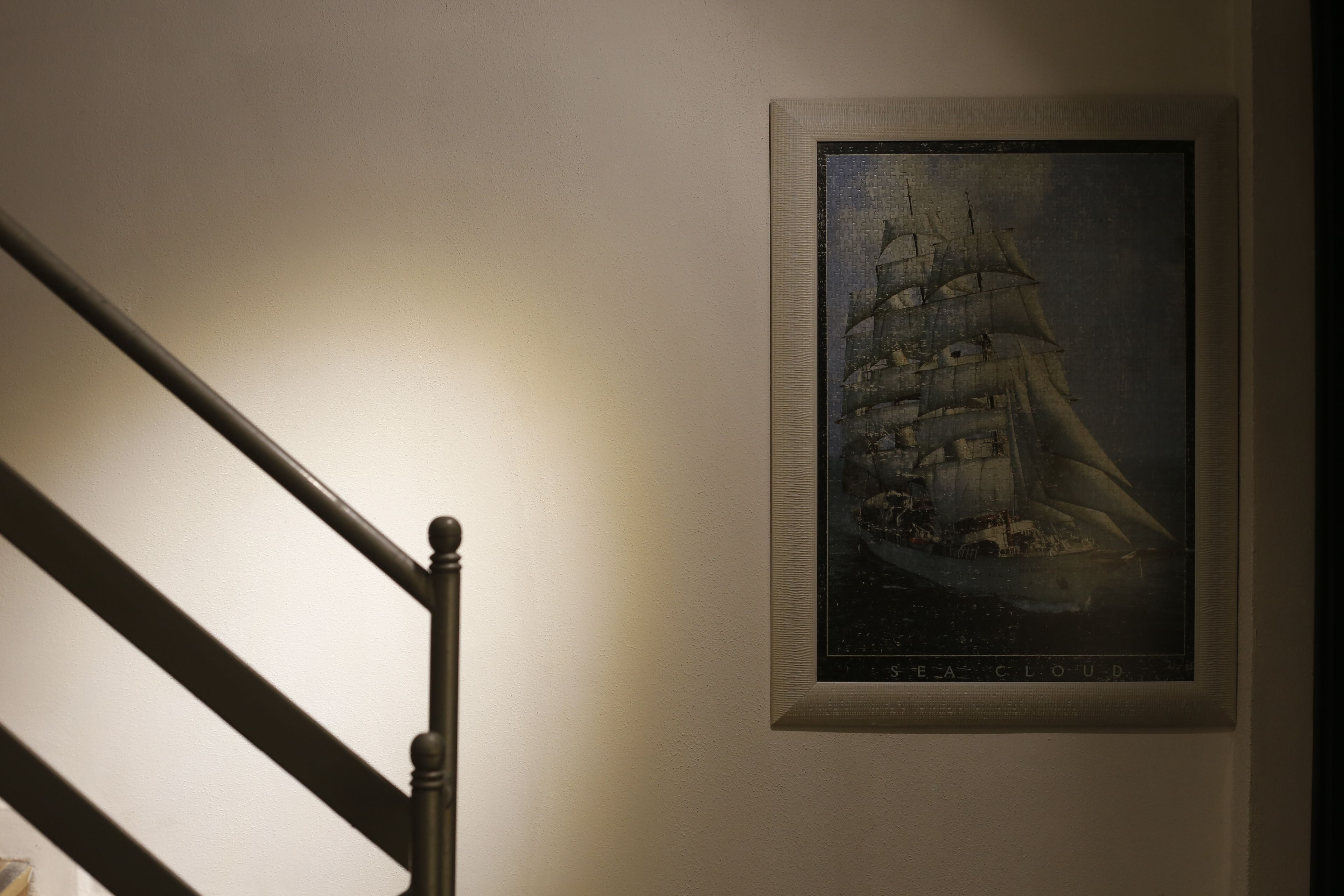 A framed picture of a sailing ship on a wall.