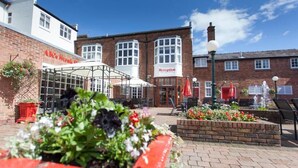 A brick building with a reception area and outdoor seating. - The Northwick Arms (Evesham)