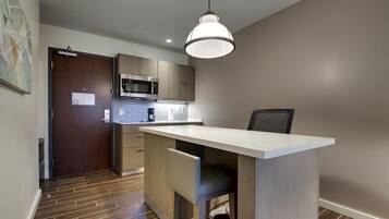 A modern kitchen with a microwave, coffee maker, and a pendant light.