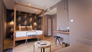 Um quarto moderno com uma cama de madeira, uma mesinha redonda e um espaço de escritório.