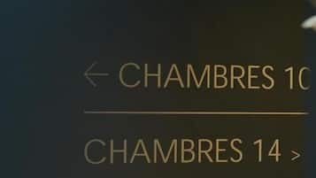 Hinweisschilder für 'Chambres 10' und 'Chambres 14' in einem Hotel.
