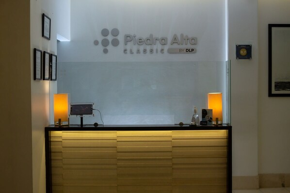 A reception desk with a sign reading "Piedra Alta Classic by DLP" and framed certificates on the wall.