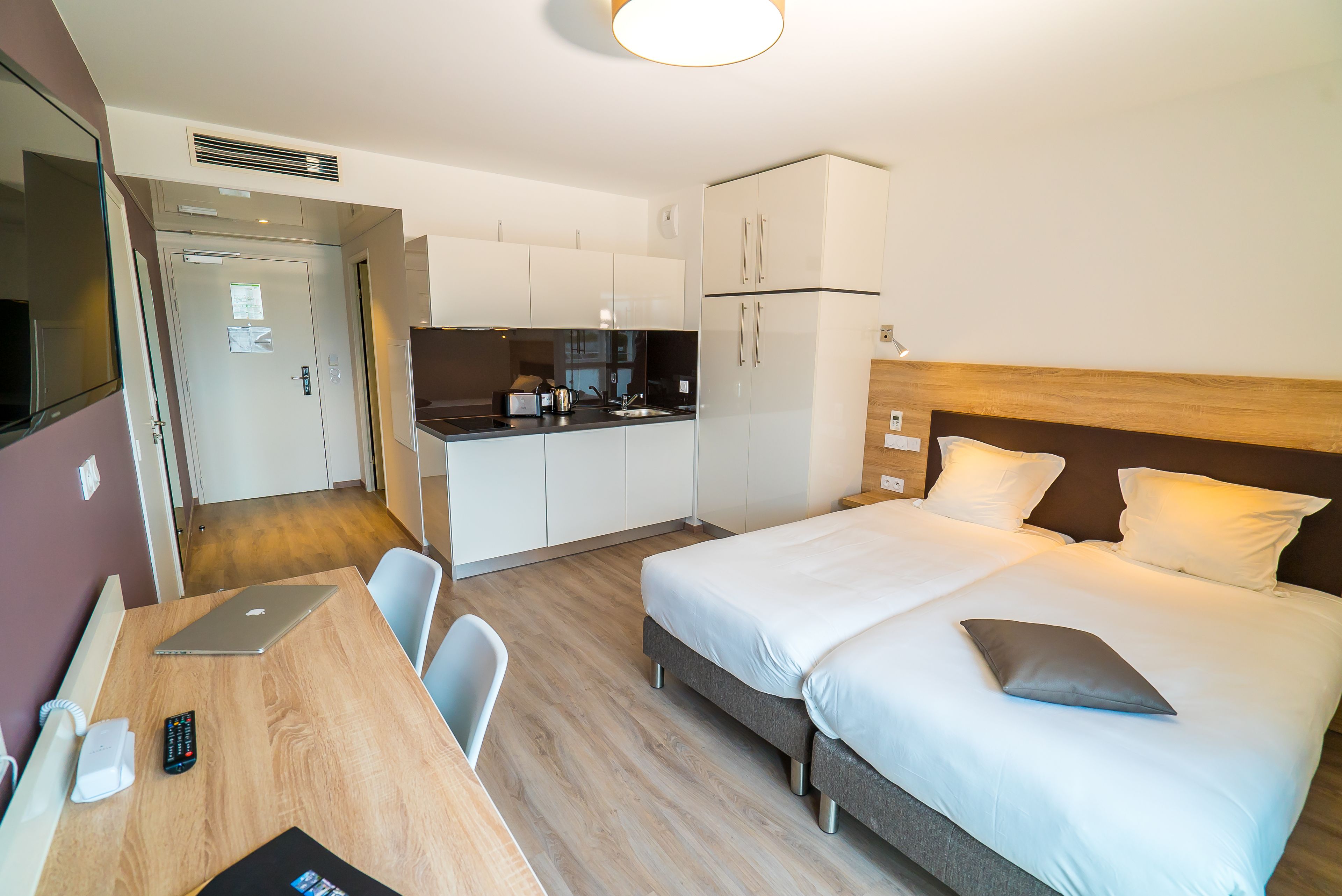 Une chambre d’hôtel comprenant un lit, une table de chevet et une kitchenette.