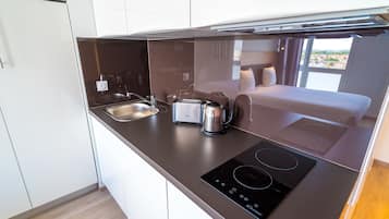A modern kitchen with a built-in stove, a coffee maker, and a toaster.