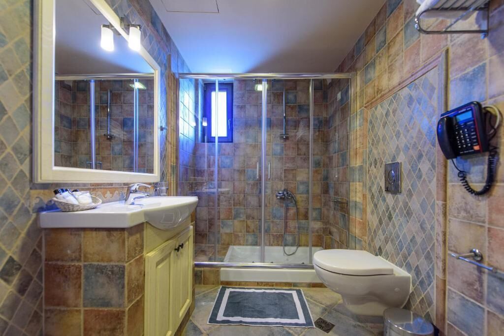 A bathroom with a shower, toilet, and sink.
